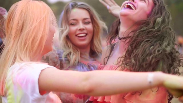 Colorful women dancing in holi colors