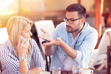 frustrated man criticizes his girlfriend who constantly talks over the phone