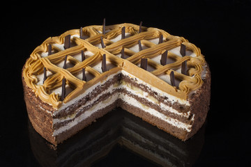 A piece of chocolate cake with white cream on a black background
