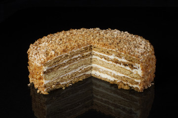 A piece of shortcake cake covered with peanuts on a dark background