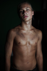 Fototapeta premium Young guy on a dark background.A strong athletic young man model.Beautiful lips and smile.Beautiful body.