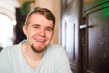 Young guy with beard smiling and looking at camera