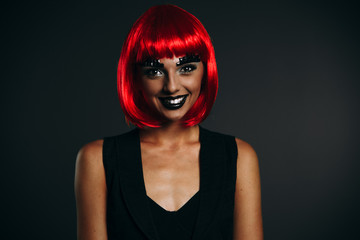 The girl in the red wig on a dark background