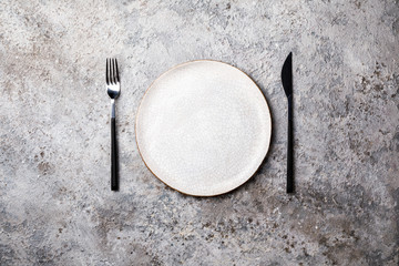 Empty plate  fork and knife on Gray Background. Diet Concept. Minimalism.  Top View. Flat Lay. Copy space for Text.