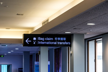 A bag claim and international transfer sign at an airport