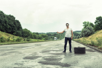 Tourist with a suitcase on the highway