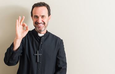 Senior priest religion man doing ok sign with fingers, excellent symbol