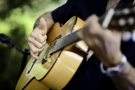 closeup detail hand playing folk guitar outdoor summer festival
