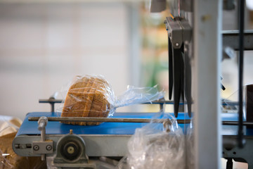 Industrial line for packaging of bakery products. Packing of bread at the factory.The machine for cutting and packing in a factory for the production of bread.