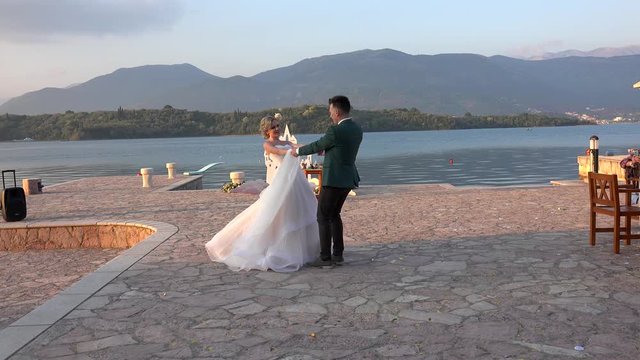 Bride and groom dancing on the pier of Kotor Bay.