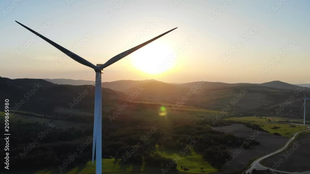 Wall mural panoramic aerial view of wind turbines with rotating blades on summer fields with beautiful summer f