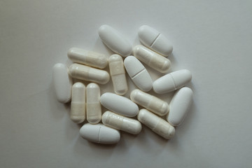 Cellulose white capsules of magnesium citrate and caplets of calcium citrate in a heap