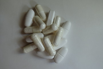 View of heap of white capsules of magnesium citrate and caplets of calcium citrate