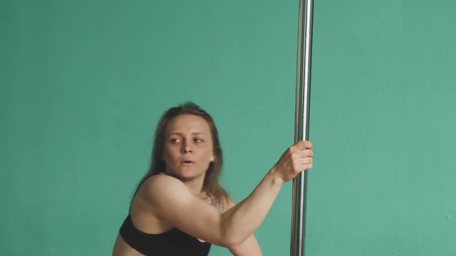 Young woman training pole dance in class