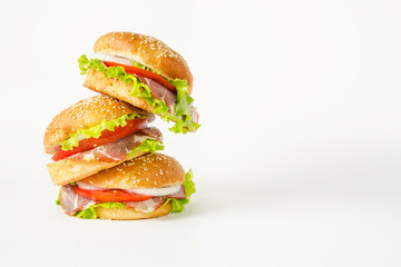 Stack of three falling hamburgers standing on a light background