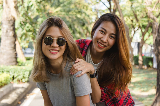 Happy young asian women couple playing to each other while they do city trip in warm sunlight morning weekend. City and nature lifestyle of Young women. Lifestyle in the city activity concept.