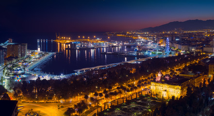 Malaga city with seafront and harbor in the night