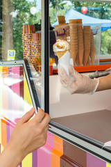 Seller through the window gives the buyer a glass of soft cream ice cream. Street Trading © alexey_arz