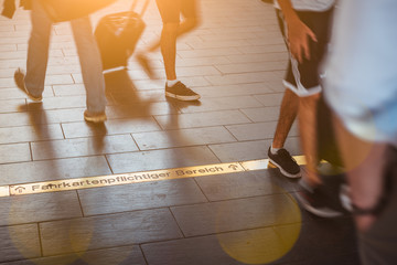 Moving blurred crowd in the metro in Germany. People feet and sunbeams