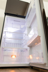 A open fridge in the kitchen. Empty clean refrigerator.