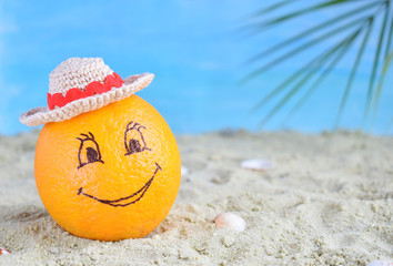 Fototapeta na wymiar Creative minimal summer idea. Orange citrus hipster in bamboo hat on sand. Tropical beach concept. Creative art. Fun party Mood. Copy space
