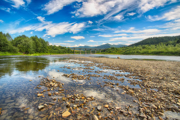 Mountain river stream of water in the rocks with majestic blue sky