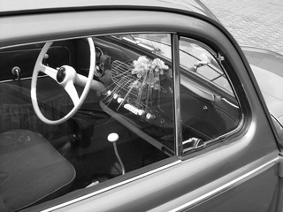 Blick durch die Seitenscheibe eines deutschen Kleinwagen auf das Armaturenbrett mit Vase und...