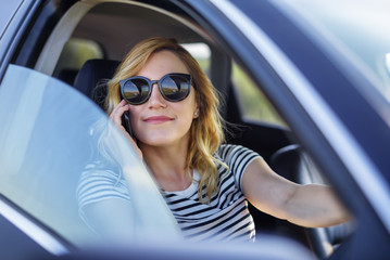 Woman speaks on the phone in the car.