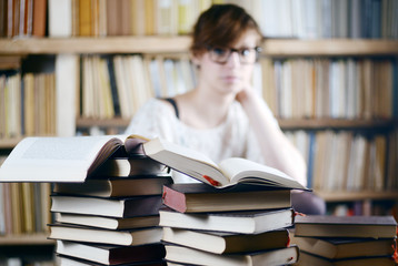Woman in the Library with piles of Books - junge Frau in einer Bibliothek studiert die Bücher