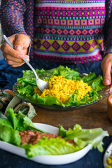 Woman hands holds cooked bulgur wheat grain porridge with turmeric powder, garlic and spices served for lunch or dinner. Traditional arabic, asian food. Vegan vegetarian healthy food