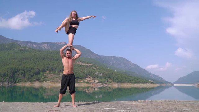 A beautiful girl with long hair stands on the shoulders of a guy in Turkey