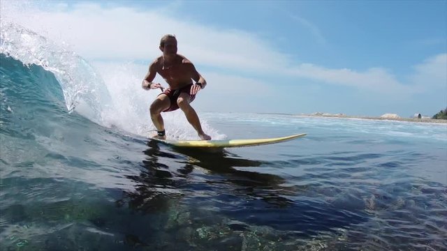 Amateur surfer rides ocean wave. Jailbreak surfspot near the island of Himmafushi, Maldives