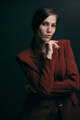 Portrait of a stylish business woman in a jacket on a dark background