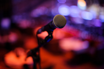 Microphone with metal body in holder on the blurred background