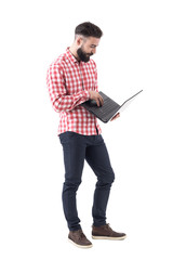 Bearded modern millennial hipster business man working and using laptop computer. Full length isolated on white background. 