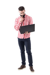 Young business man employee holding and working on laptop computer. Full length isolated on white background. 