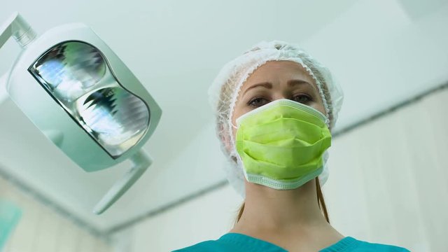 Female physician wearing bouffant cap, plastic surgery, cosmetology, patient POV