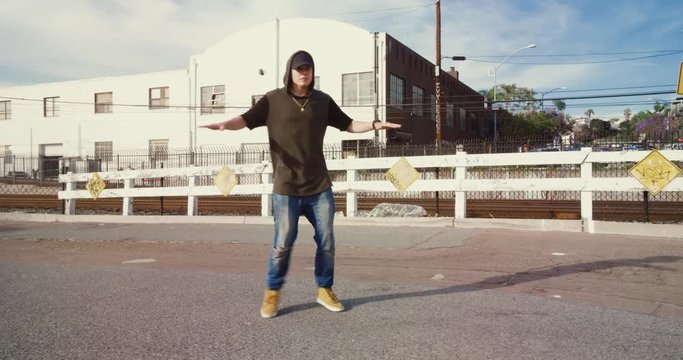 Man hip hop dancing outside in street on sunny day 