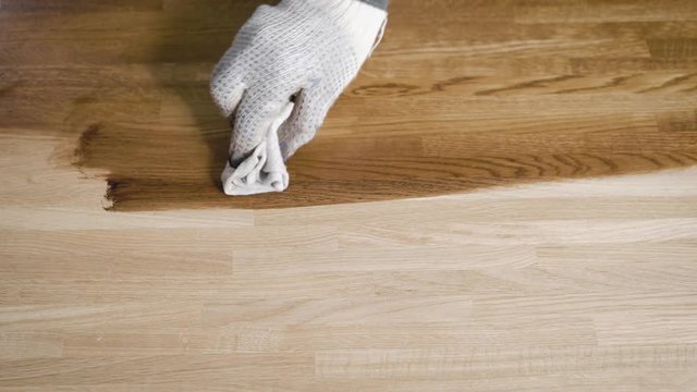 Shot from above of a handyman a impregnate with oil ready piece of wood.