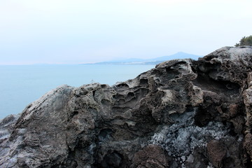 Fototapeta na wymiar The Daepo Jusangjeolli basalt columnar joints and cliffs on Jeju Island, South Korea