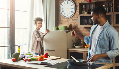 Young black family preparing dinner together in kitchen