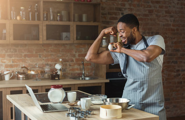 Black man baking cookies and having fun in kitchen