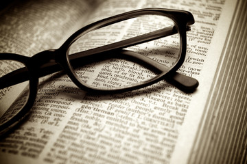 Black glasses on old book