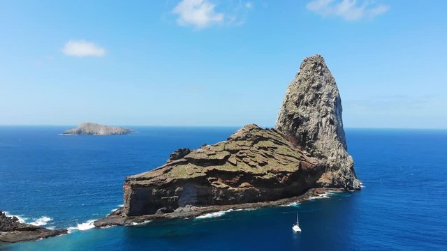 Aerial view of cathedral rock (Motutakaae) islet, spire rock formation, south coast of Ua Pou island - South Pacific Ocean, Marquesas Islands, landscape of French Polynesia from above, 4k