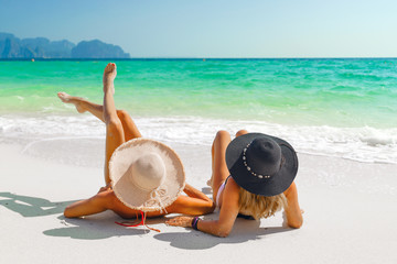 Fototapeta na wymiar women sunbathing lying down on the tropical beach
