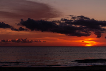 Beautiful sunset at the sea with the sky with some scattered clouds.