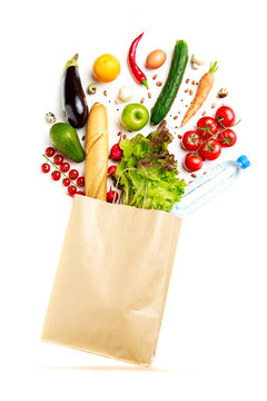 Photo of paper bag with vegetables, fruit, loaf and bottle of water