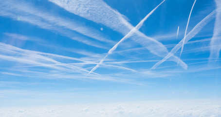 Multiple contrails cross paths through the sky