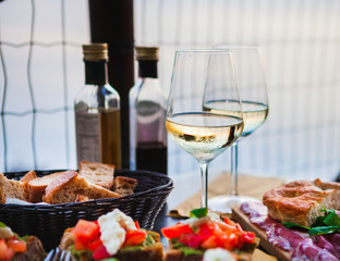 Romantic dinner for two at sunset. White wine and Tasty italian snack: fresh bruschettes  and meat on the board in outdoor cafe with amazing view in Manarola - 209889354