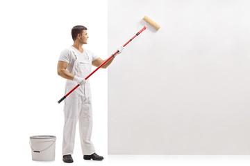 Painter painting a wall with a paint roller